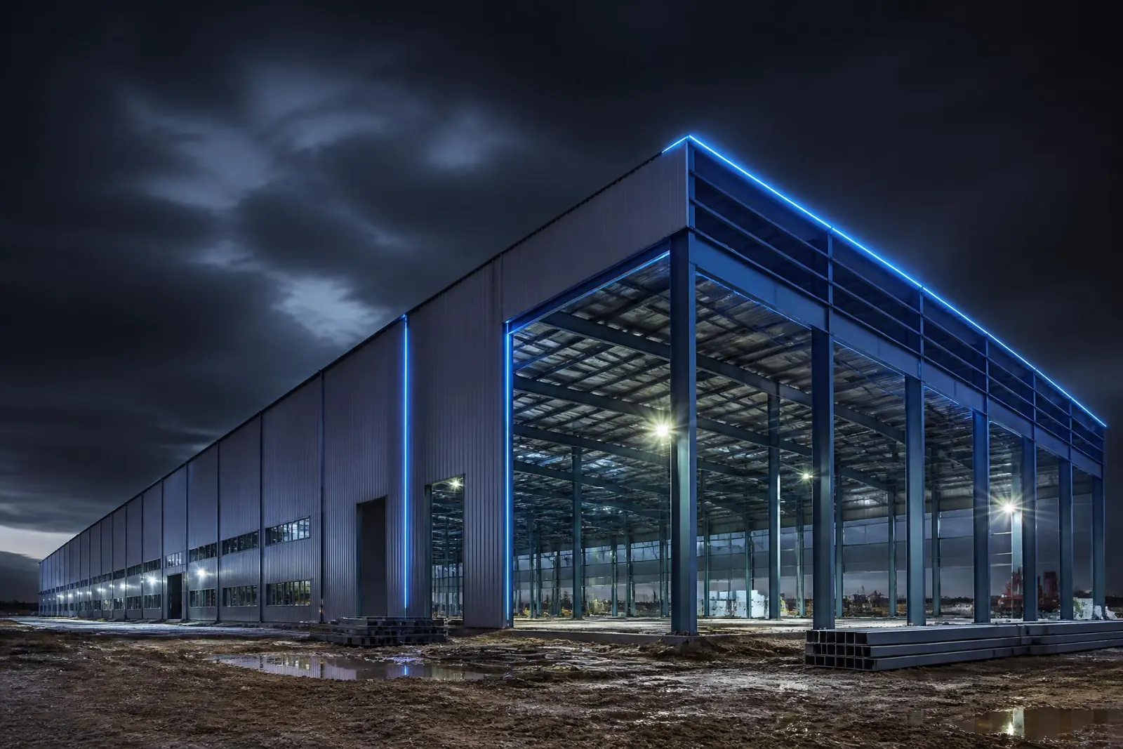 Pre-engineered steel warehouse structure erected at dusk